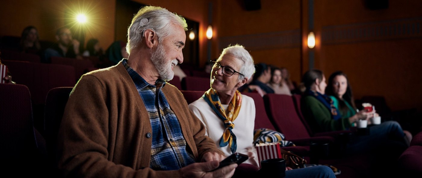 Adulto con implante auditivo disfrutando el cine